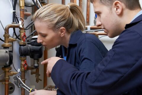 Women and man fixing water pump